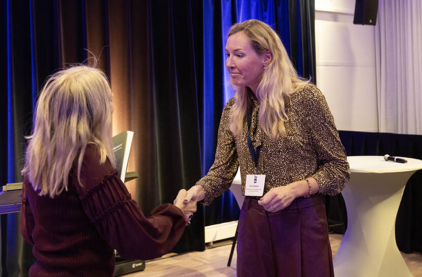 Anne-Marie Buis overhandigd het eerste exemplaar van de essaybundel 'De vierde macht – reflecties op een goede overheid’ aan Eva Heijblom